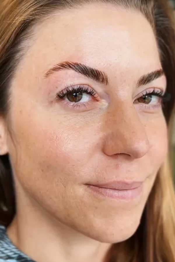 Close-up of a laminated eyebrow paired with natural volume lash extensions.