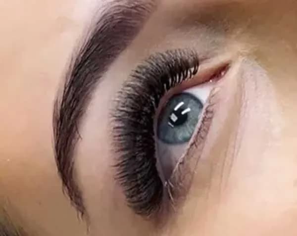 Close-up of a full lash extension fill on a grey-blue eye.