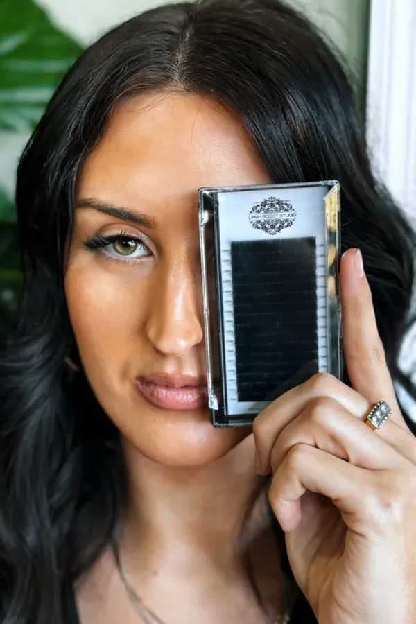 A Lash Addict Studio artist holds up a tray of handmade lash extension fans.