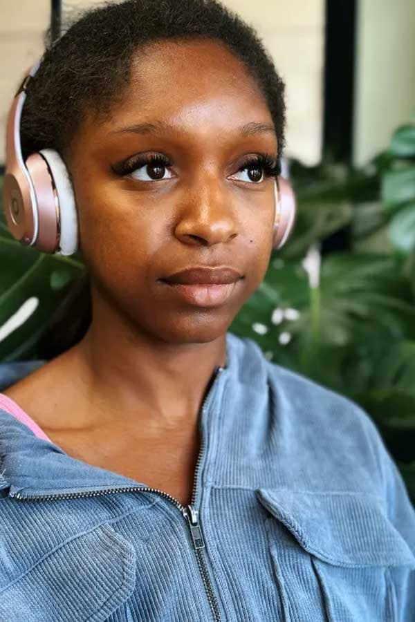 Close-up of a natural volume lash extension set on a client wearing headphones.