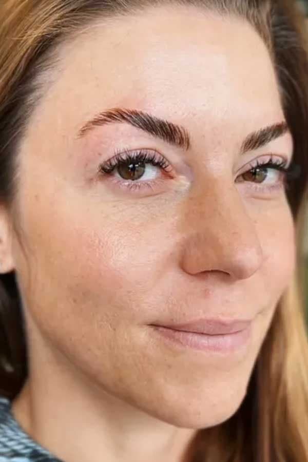Close-up of a laminated eyebrow paired with natural volume lash extensions.
